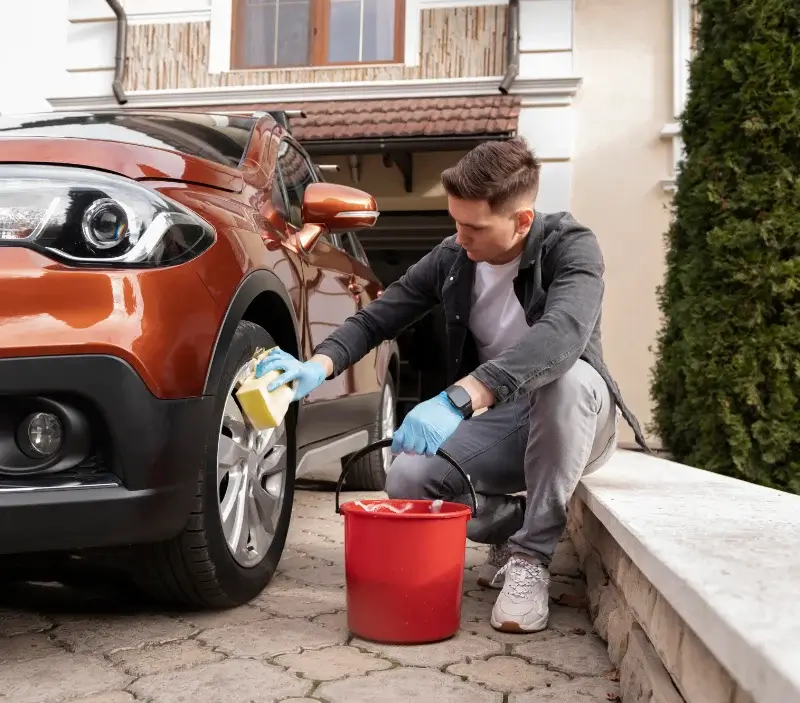 Lavage auto à domicile Saint-Léon-sur-l'Isle : professionnel intervenant sur un véhicule